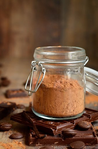 Cocoa Powder In A Glass Jar On Rustic Background.